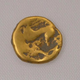 An uninscribed gold stater coin found at the site.